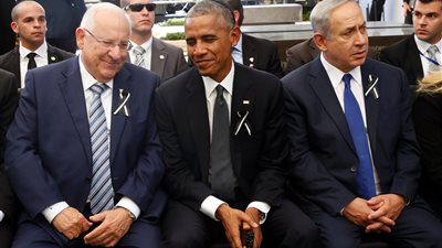 أوباما وكلينتون يضحكان خلال تشييع جثمان 