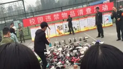 مدير مدرسة يحطم الأجهزة الإلكترونية للطلاب بفأس (صور)