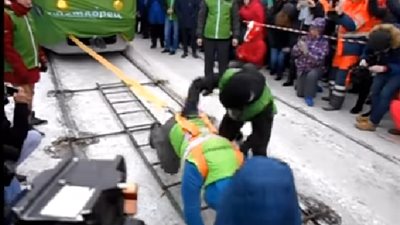 شاهد.. مرأة تسحب عربتي ترام تزن 18 طناً في جو متجمد ! (فيديو)