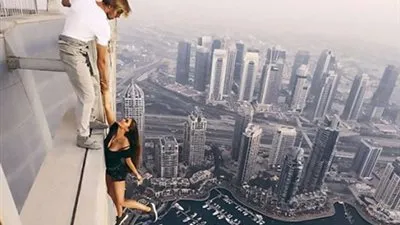 في مشهد مروع.. عارضة روسية تغامر بحياتها من أعلى أبرج دبي (فيديو)
