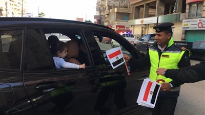 قيادات الشرطة توزع الورود وأعلام مصر على المواطنين بميادين السويس (صور)  