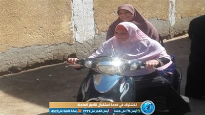سيدة تتحدى الإعاقة وتستقل دراجة بخارية للتصويت في التعديلات الدستورية بأسيوط (صور)