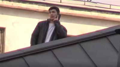 رجل يصعد على سطح السفارة الفنزويلية في موسكو