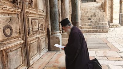 مطران القدس يتلو الصلوات أمام أبواب كنيسة القيامة المغلقة 