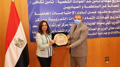 سعفان ومحافظ دمياط يتبادلان الدروع في حفل تسليم بوالص التأمين للعمالة غير المنتظمة