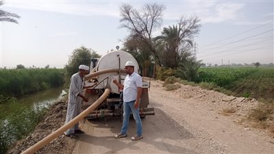 سيارات لرش المياه لتخفيف درجات الحرارة بشوارع أبومناع غرب في قنا