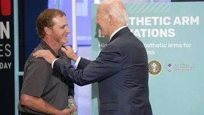 التقدم في السن يعيق ارتداء بايدن قميصا تلقاه هدية أمام الجمهور