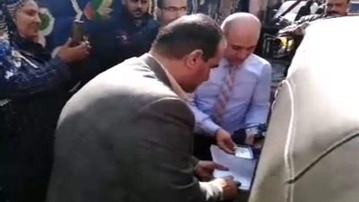 رئيس لجنة يساعد سيدة من ذوي الاحتياجات الخاصة للتصويت في القليوبية