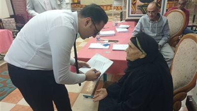 رئيس لجنة يساعد سيدة كفيفة على الإدلاء بصوتها داخل لجنة عمرو بن العاص بزفتى