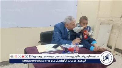 في موقف انساني.. رئيس لجنة في الفيوم يحمل طفل ناخب ليمكن والده من الانتخاب